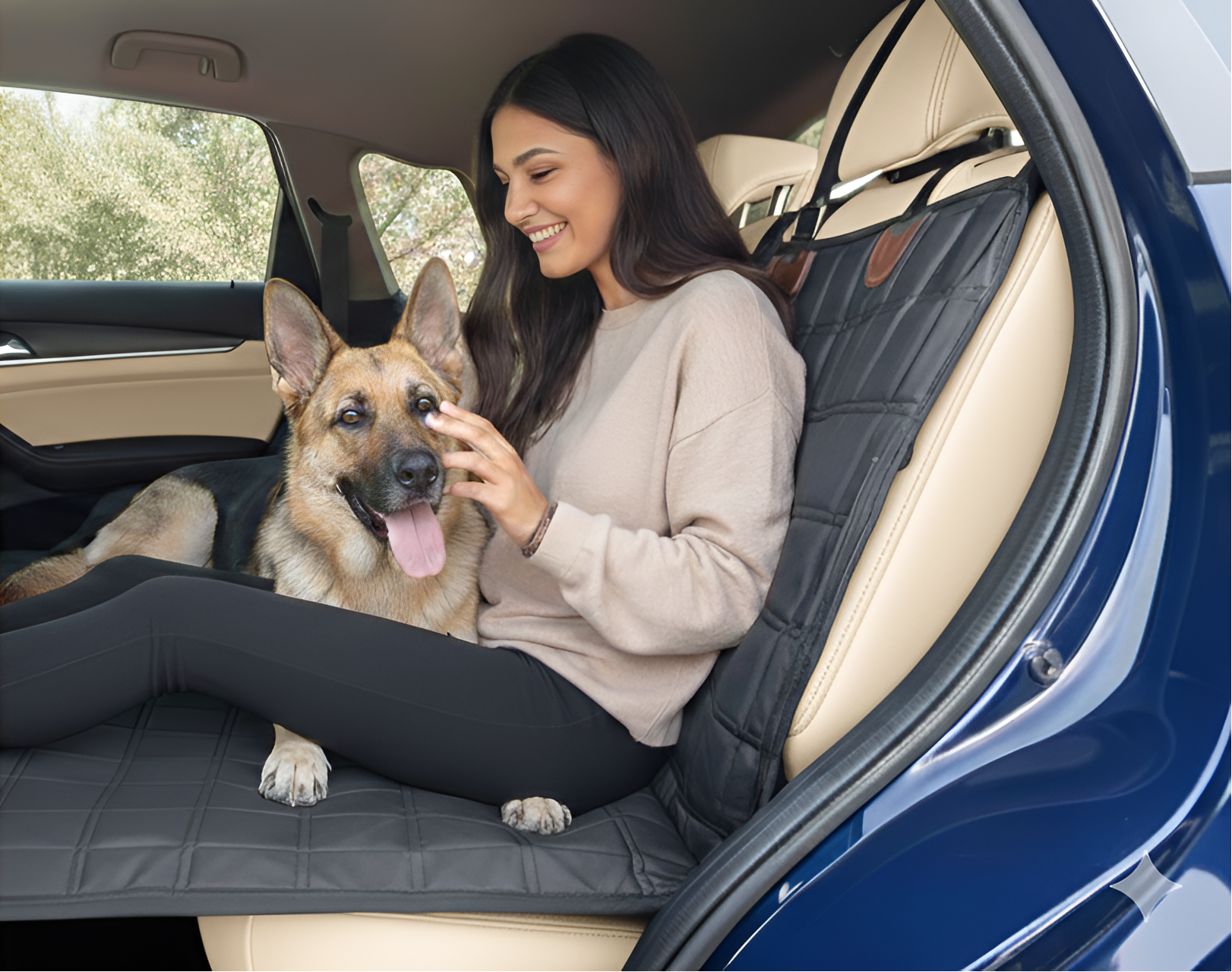 Woman sitting in a car with a dog on a pet seat cover